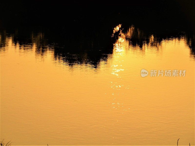 日本。十月。江户川的日落。反射。