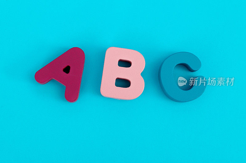 蓝色背景上的木制大写字母A、B、C