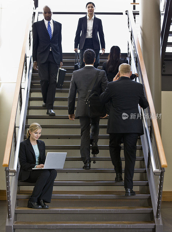 女商人在楼梯上使用笔记本电脑