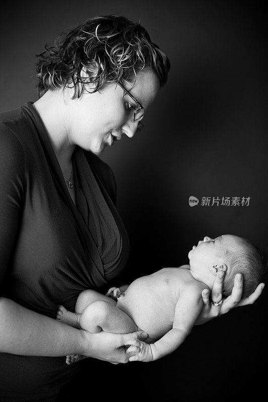 新妈妈抱着她刚出生的宝宝，让她平静下来