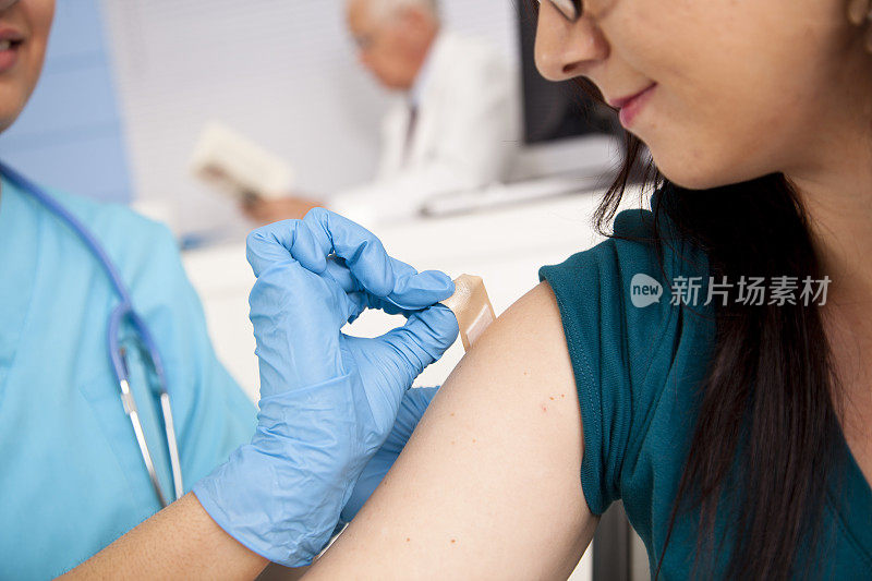 医生:在药房诊所给病人注射流感疫苗的护士。