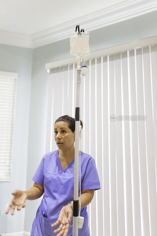 拉丁裔女护士站在输液柱旁