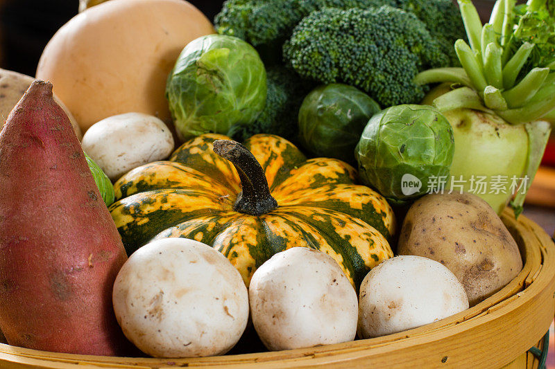 五彩缤纷的秋天蔬菜装满了一个柳条篮子。
