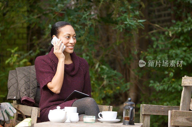 一个年轻女子在户外的咖啡馆里打电话