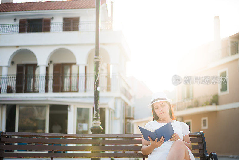 一个女人坐在长凳上看书