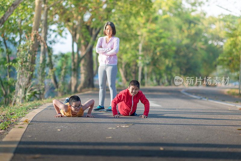 家庭运动快乐活跃的母亲和孩子在户外慢跑，在森林里跑步