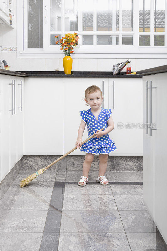 小女孩在厨房打扫地板