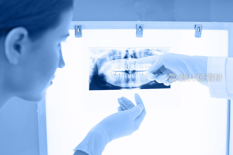 年轻的女牙医分析牙科x光图像