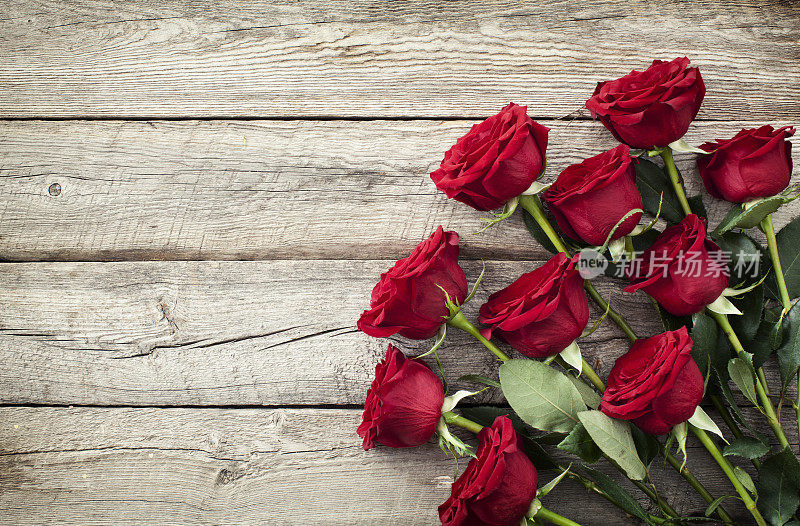 情人节红玫瑰花束在古老的乡村木材背景