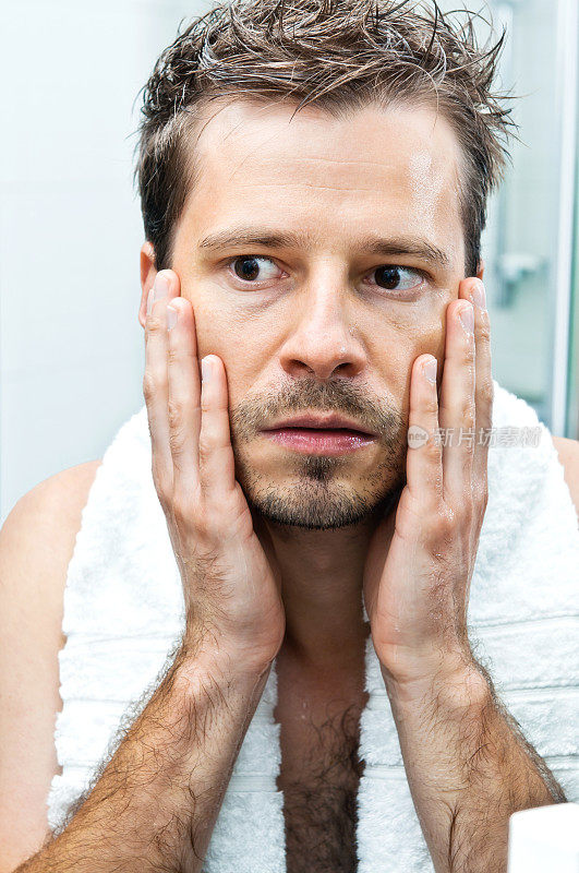 男人担心脸上的皮肤和皱纹，浴室里的镜子