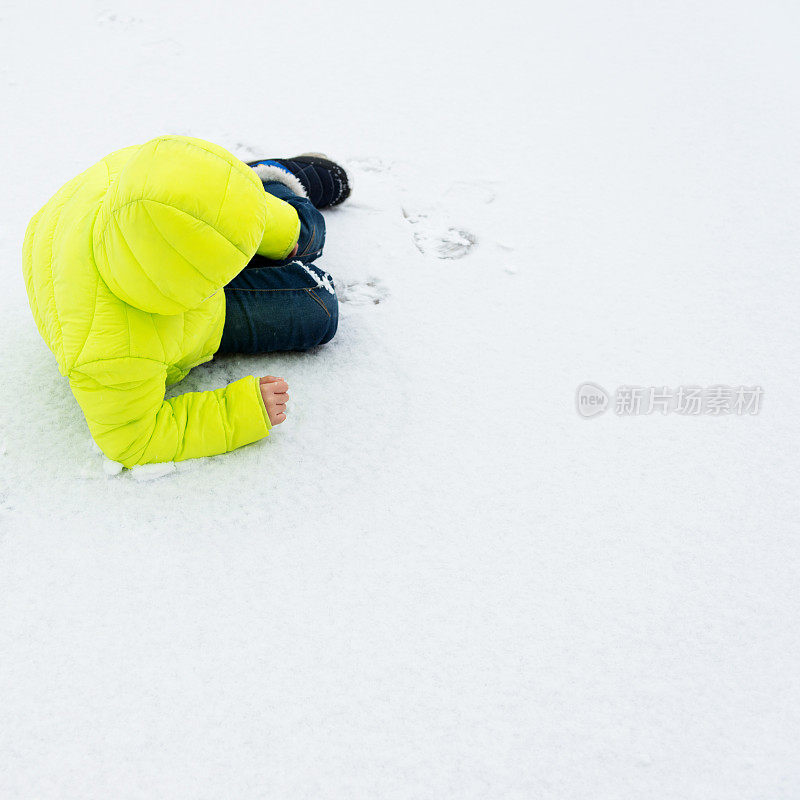 男孩躺在雪地上