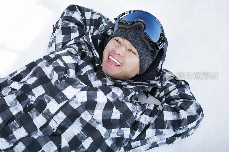 快乐的滑雪板躺在雪地上
