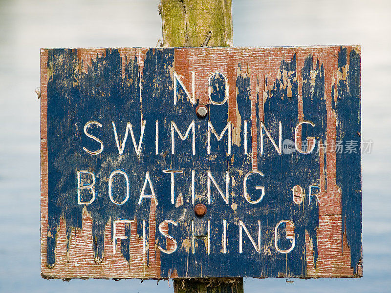 禁止游泳、钓鱼的旧木牌油漆剥落。