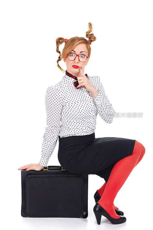 惊讶有趣的女商人戴着眼镜坐在公文包上