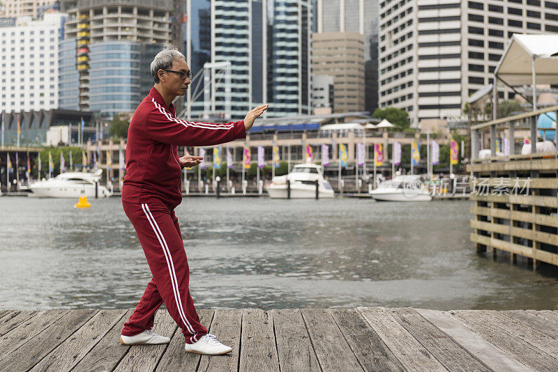 成熟的中国男子在码头边练习太极拳