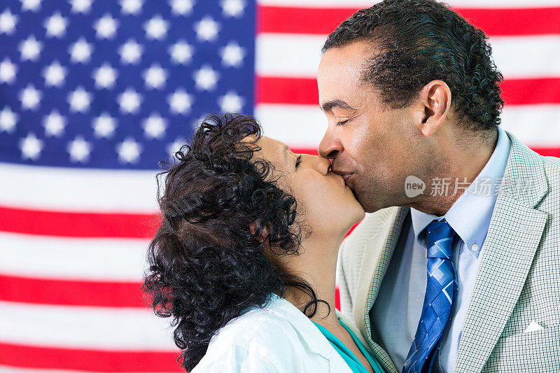 一对情侣在美国国旗前接吻