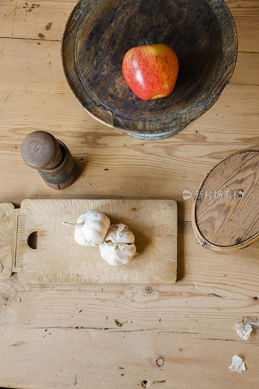 苹果，杵，臼和大蒜放在木桌上。
