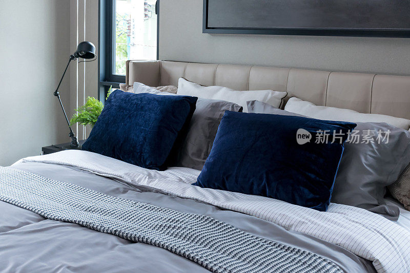 蓝色枕头和黑色台灯的现代卧室