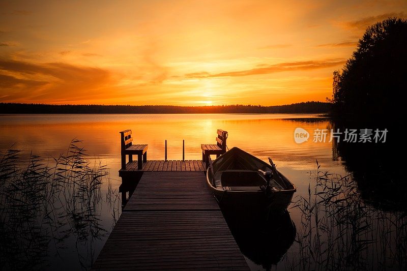 夕阳在芬兰湖边的钓鱼码头上