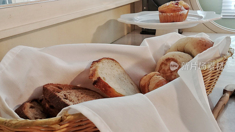 篮子的大陆早餐面包，松饼在盘子，自助餐桌子