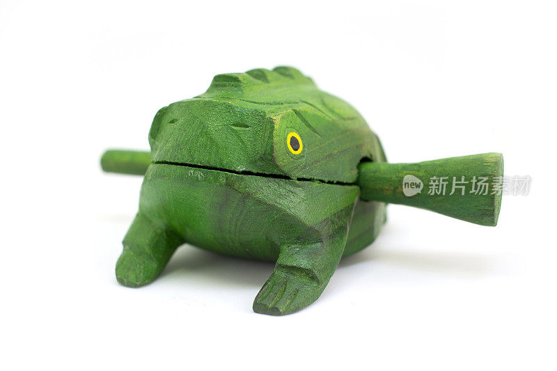 玩具木头呱呱绿色青蛙与棍棒孤立在白色