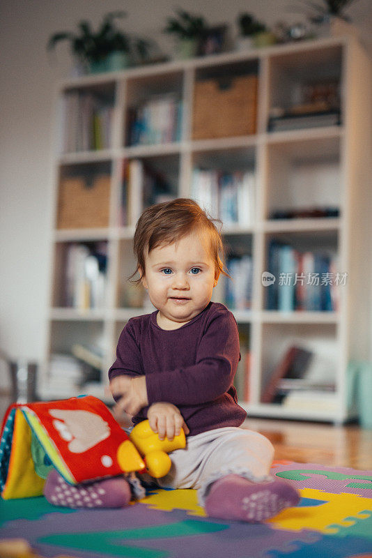 可爱的小女孩在客厅和她的玩具