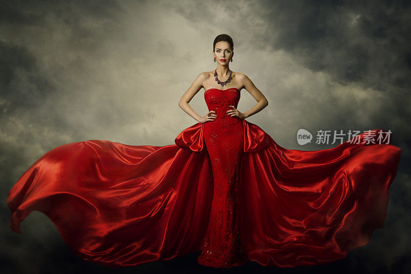 时装模特艺术礼服，优雅的女人在红色复古长袍，丝绸面料在风暴中飘扬