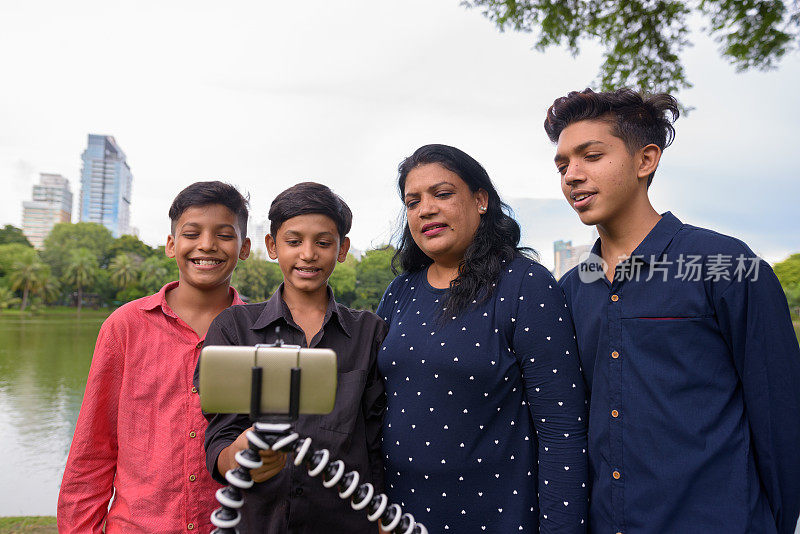 在泰国曼谷的朗菲尼公园，印度家庭用手机拍短视频