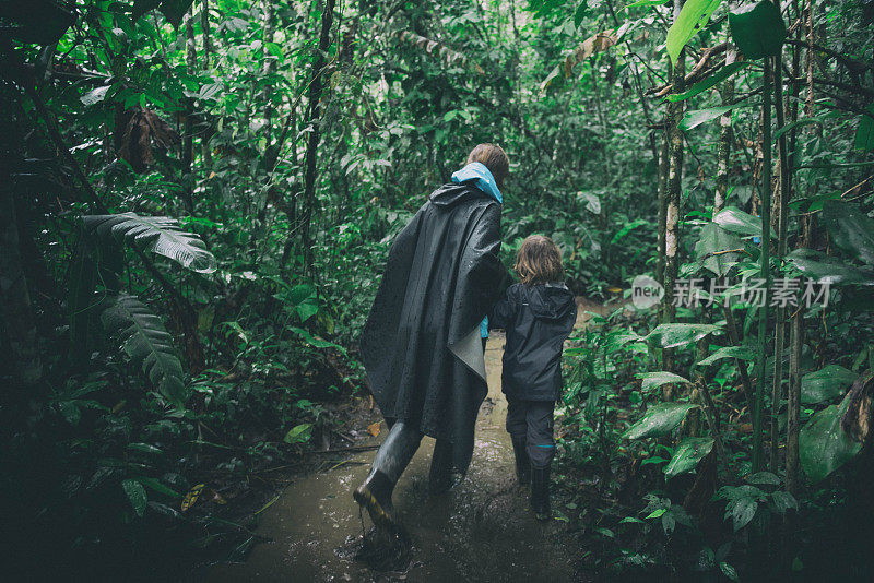 母子冒雨在亚马逊丛林徒步旅行。