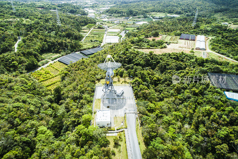 一座有抛物面天线和太阳能电池板的山。