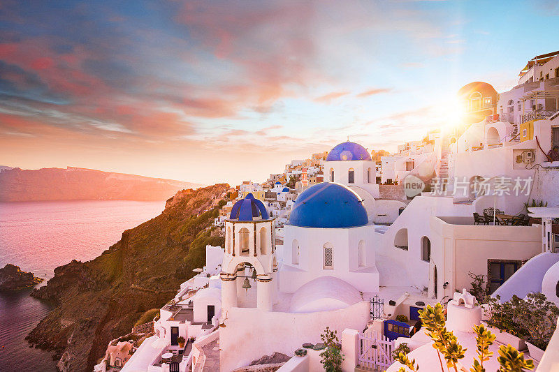 希腊圣托里尼岛蓝色圆顶教堂的日落景色