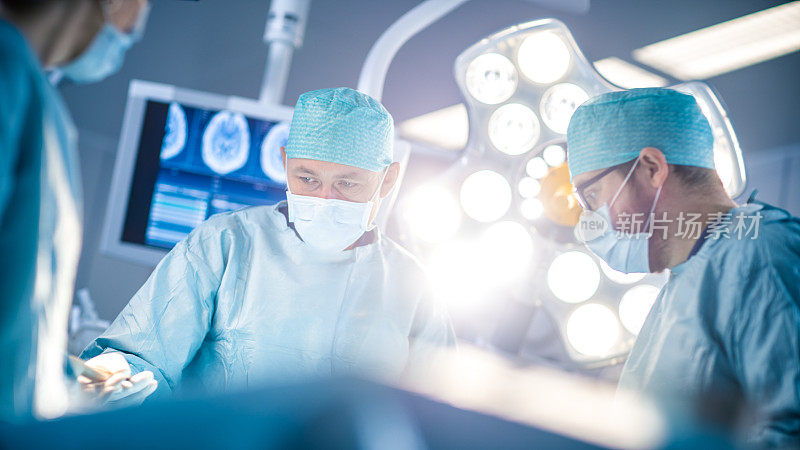 手术室低角度拍摄，助理在手术中向外科医生发放器械。外科医生做手术。从事外科手术的专业医生。