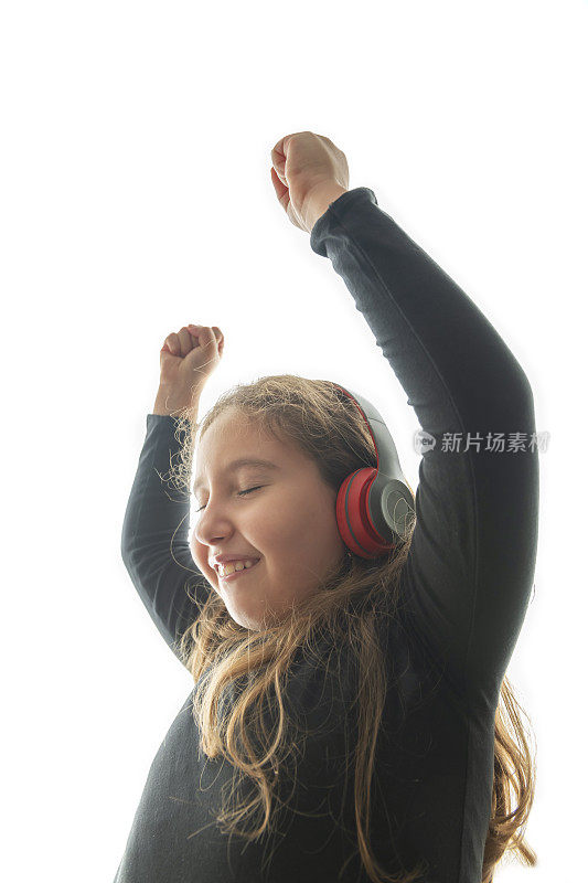 小女孩戴着耳机听音乐，一个孩子随着白色背景音乐跳舞