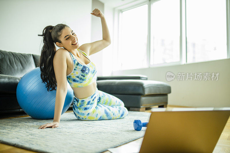 美丽的女性私人健身教练在新常态期间在家进行在线直播