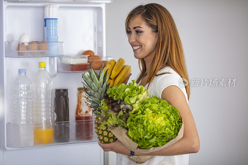 一个成熟的白人女人从冰箱里拿东西的侧视图。