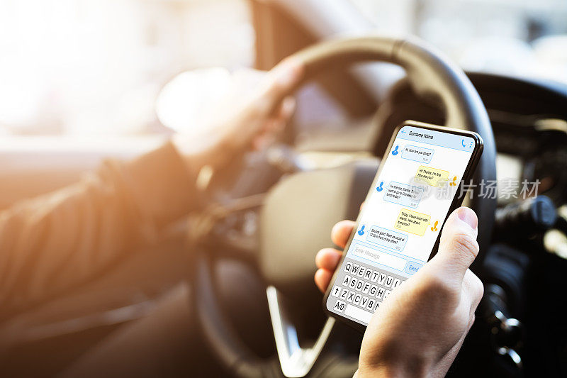 男人开车时在手机上发短信