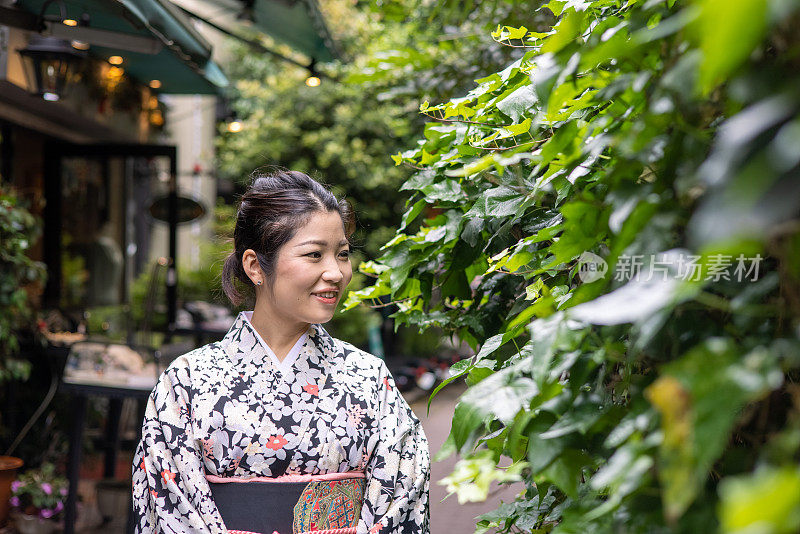 穿着和服的日本妇女在街上看绿叶