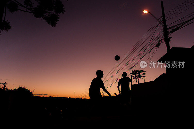 库里提巴，Paraná，巴西——两个男孩在街上踢足球。