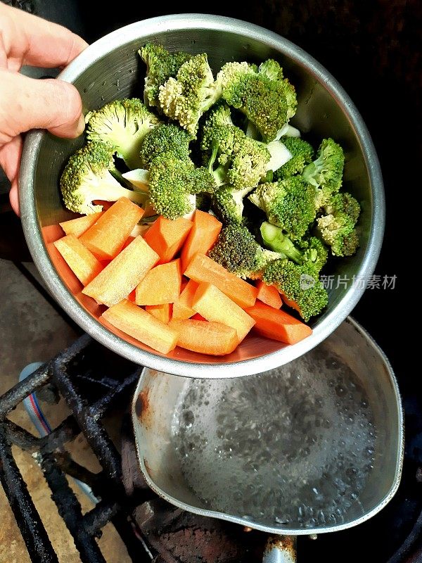 在炉子上用热水煮胡萝卜和花椰菜-食物准备。