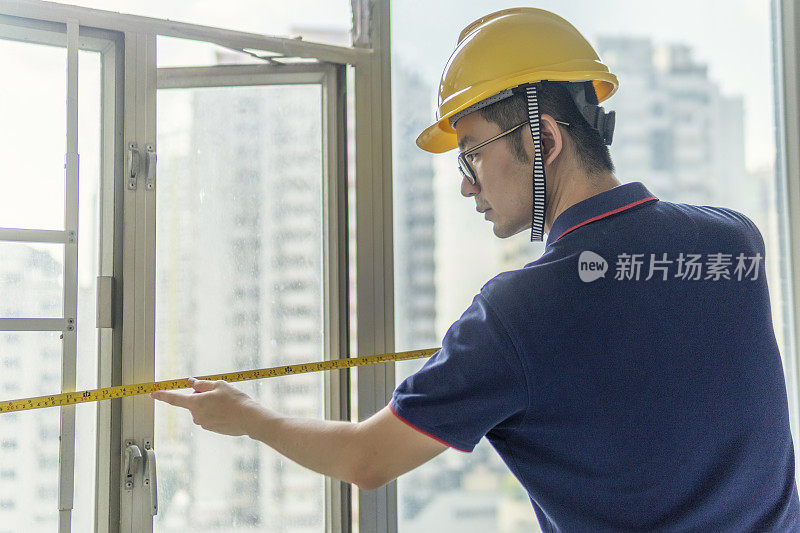 亚洲男工程师在翻新工地带着头盔工作