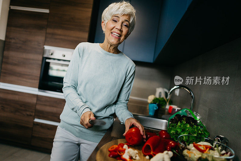 一位女士在厨房里用笔记本电脑打电话