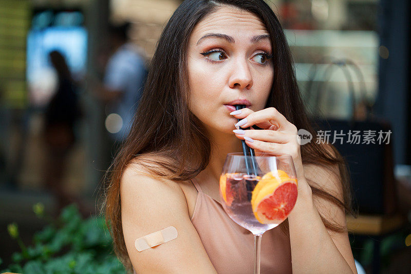 接种疫苗的女人喝着鸡尾酒