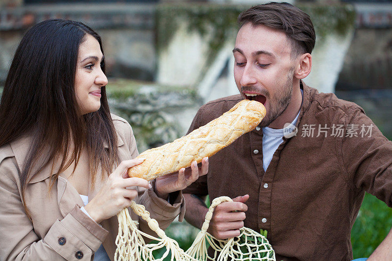 年轻女子用面包喂男友