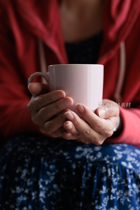 一个女人拿着咖啡杯