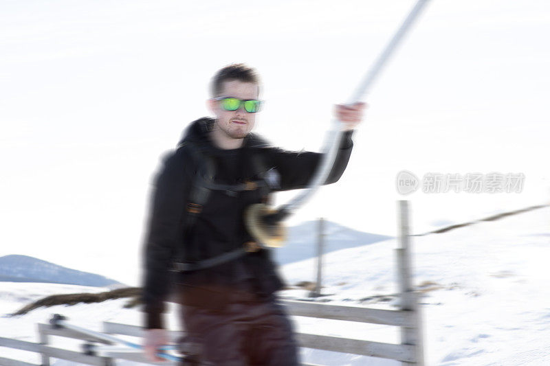 一名男子乘坐滑雪缆车到达雪道顶部