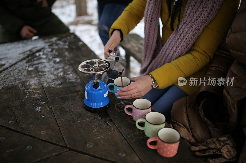 朋友们在雪堆上喝着热饮的照片