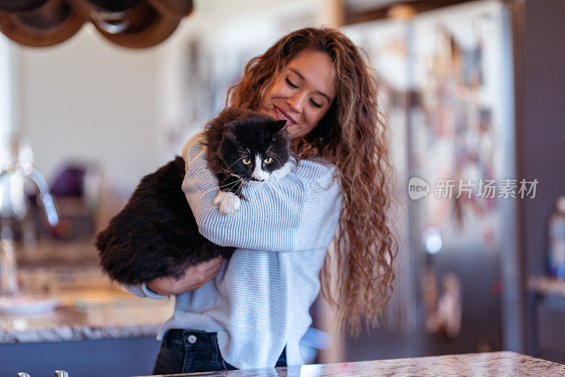 美丽的哥伦比亚女人依偎着她的宠物猫