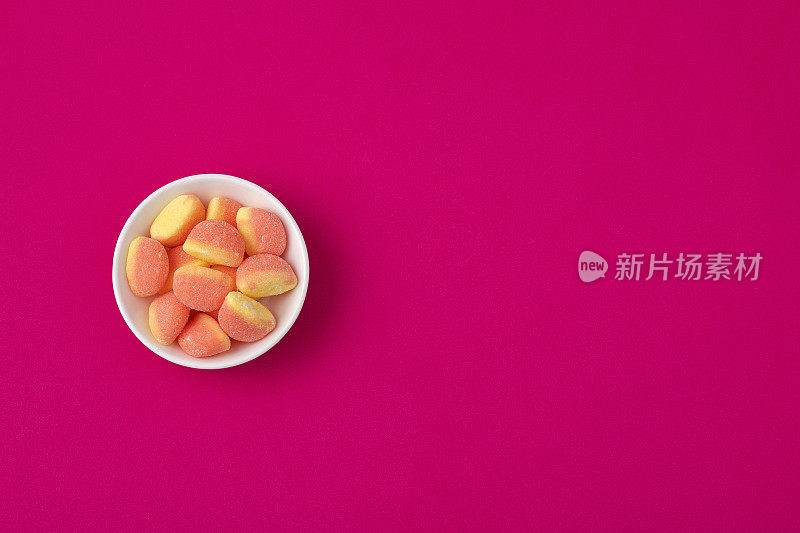 甜甜的果冻糖果在紫色泡沫背景