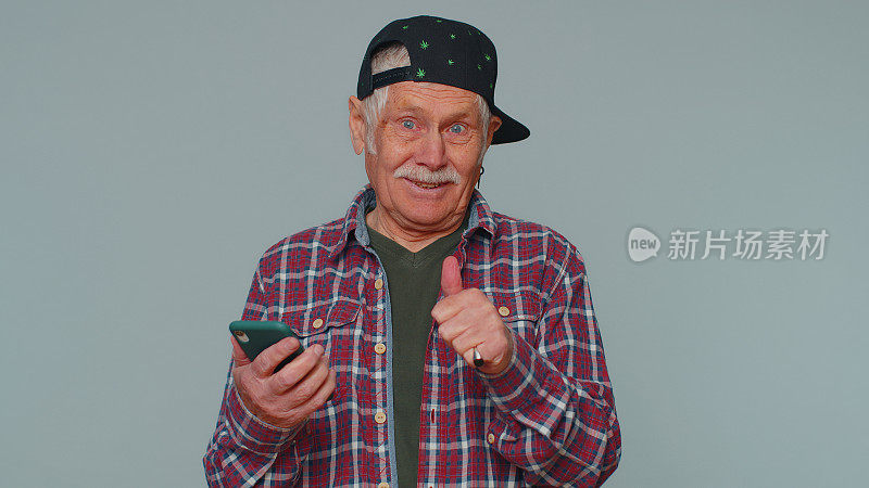 老年男子利用手机打字，在网络上发帖，浏览短信，沉迷于社交网络