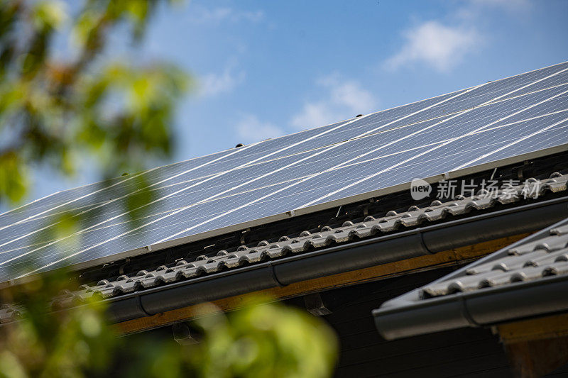 在住宅屋顶上生产清洁能源的太阳能电池板